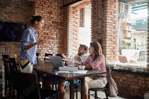 Waitress and young couple arguing about noise