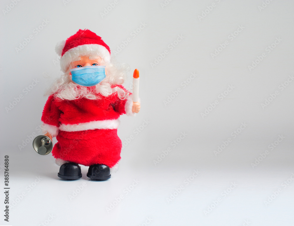 Toy Santa Claus in a medical face mask. Christmas background with a copy space