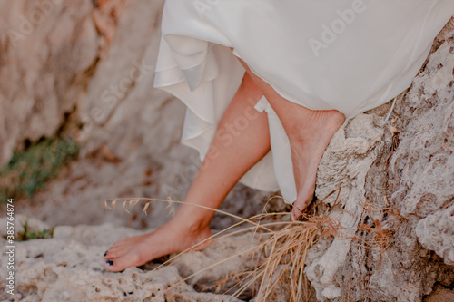 The girl's feet walk on the autumn grass.