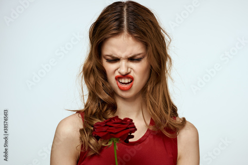 Beautiful woman in a red dress holds a rose in her hand a gift flowers decoration attractive look © SHOTPRIME STUDIO