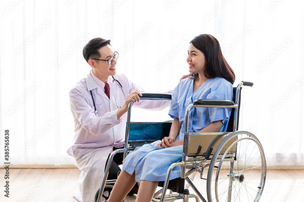 Doctor talking to woman in wheelchair after surgery. Doctor consulting, encourage patient about treatment before discharging from hospital. Medicine, Age, Health Care and People concept, Covid19. Doctor talking to woman in wheelchair after surgery. Doctor consulting, encourage patient about treatment before discharging from hospital. Medicine, Age, Health Care and People concept, Covid19.
