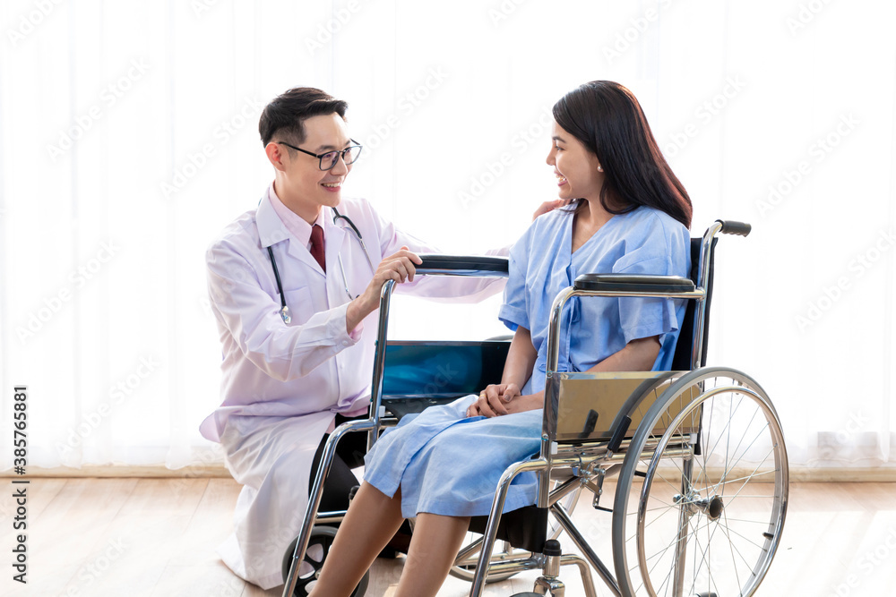 Doctor talking to woman in wheelchair after surgery. Doctor consulting, encourage patient about treatment before discharging from hospital. Medicine, Age, Health Care and People concept, Covid19. Doctor talking to woman in wheelchair after surgery. Doctor consulting, encourage patient about treatment before discharging from hospital. Medicine, Age, Health Care and People concept, Covid19.