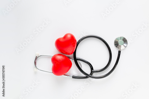 Stethoscope and red heart on white background. Cardiology concept. Two Red heart and a stethoscope on white desk.