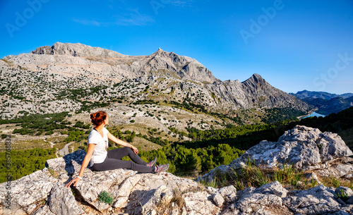 Woman hiker sitting on the rock and enjoying view to the mountain Puig Major, Mallorca island, GR 221 photo