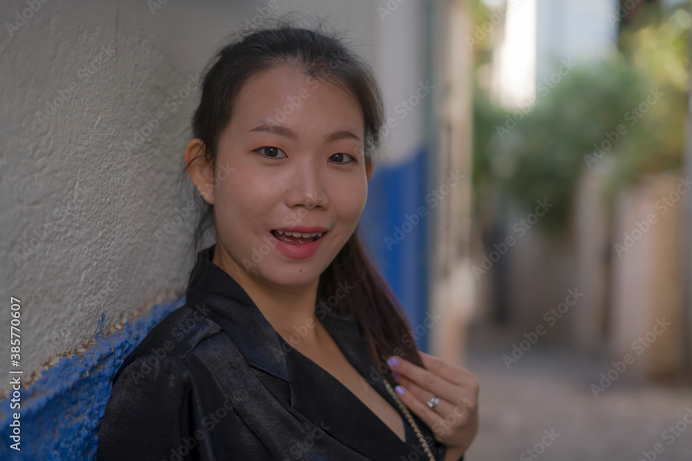 lifestyle portrait of young beautiful and happy Asian Japanese woman enjoying Summer holidays in Europe walking cheerful at Spain Andalusia village in tourism and travel concept
