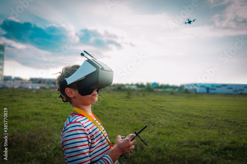 boy flying drone in virtual reality glasses outside