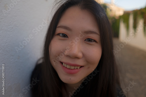 lifestyle portrait of young beautiful and happy Asian Korean woman enjoying Summer holidays in Europe walking cheerful at Spain Andalusia village in tourism and travel concept