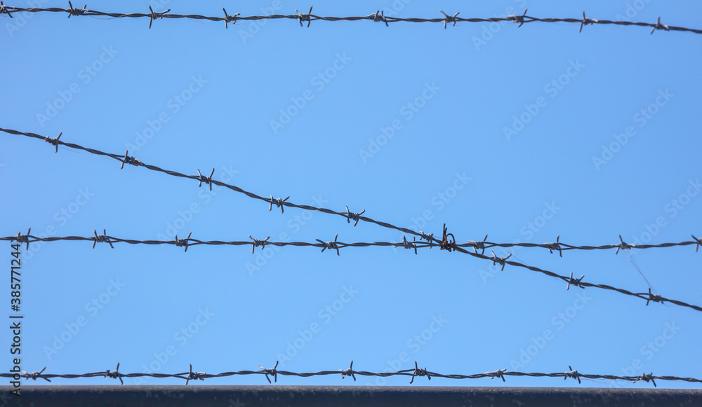 Barbed wire against the blue sky. Barbed wire against the blue sky.