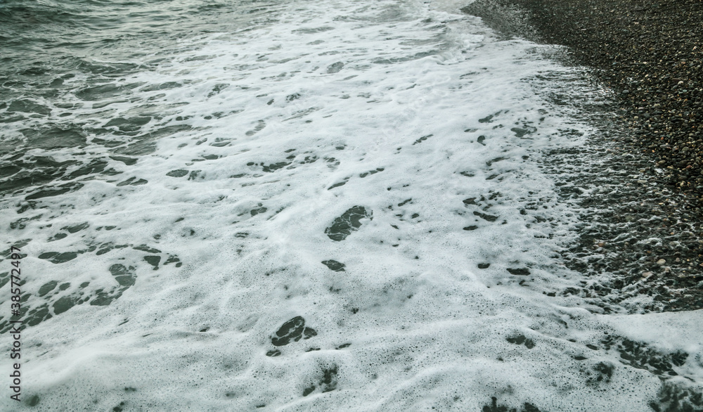 Stone pebbles on the seashore washed by a wave of water. Stone pebbles on the seashore washed by a wave of water.