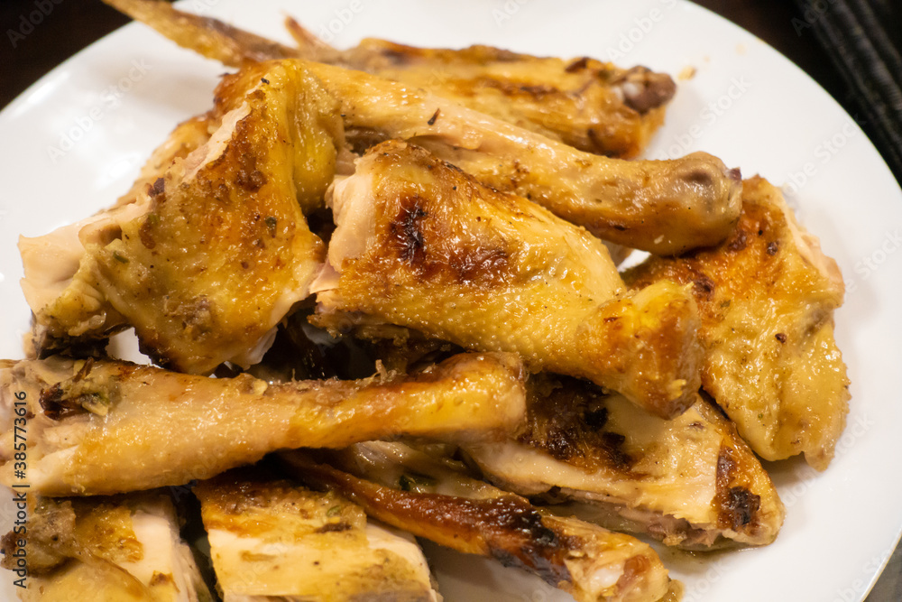 Grilled chicken placed on a white plate, ready to eat Grilled chicken placed on a white plate, ready to eat