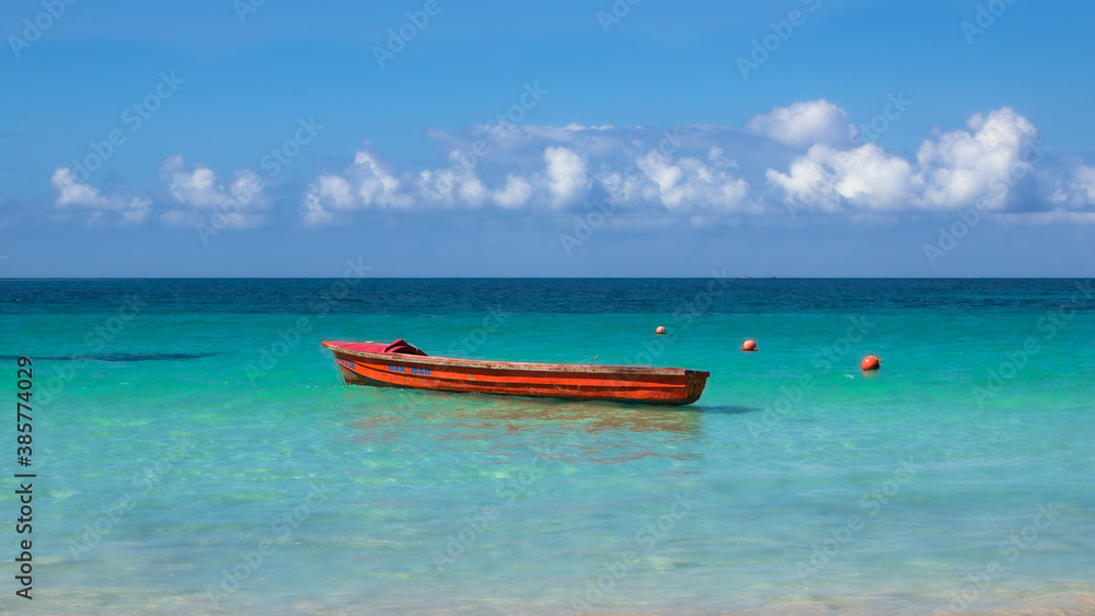 A red boat over the blue Ocean.