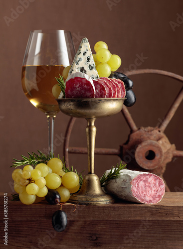 Glass of wine with snacks on a brown background.