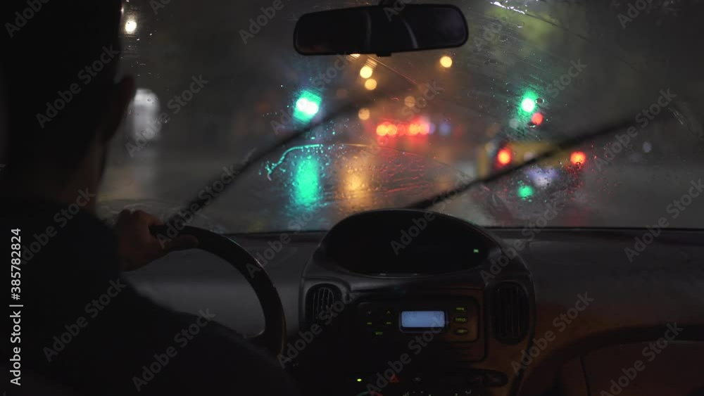 Driving in the rain at night. POV from car interior traveling a rainy dark city with colorful lights (Barcelona) Driving in the rain at night. POV from car interior traveling a rainy dark city with colorful lights (Barcelona)