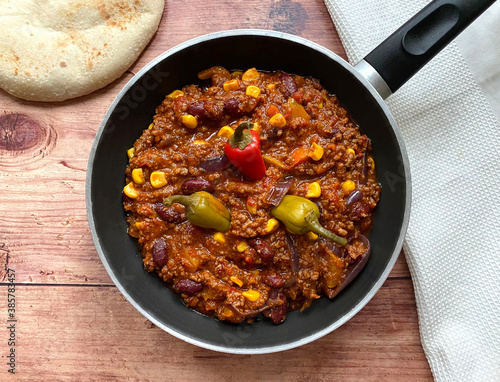 Chili con carne with minced beef, tomatoes, chili peppers, beans, corn, onions, garlic and bell pepper. Served with flat bread.