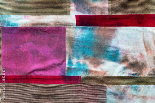 textile background - hand-stitched patchwork cloth from velvet fabric and hand-colored batik pieces photo