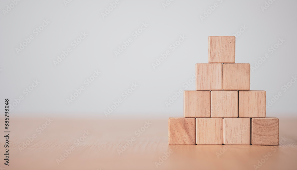 Hand putting and stacking blank wooden cubes on table with copy space for input wording and infographic icon. Hand putting and stacking blank wooden cubes on table with copy space for input wording and infographic icon.