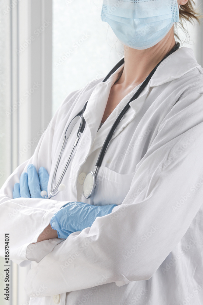 Close up image of medical worker wearing protective surgical mask and rubber gloves with crossed arms. Close up image of medical worker wearing protective surgical mask and rubber gloves with crossed arms.