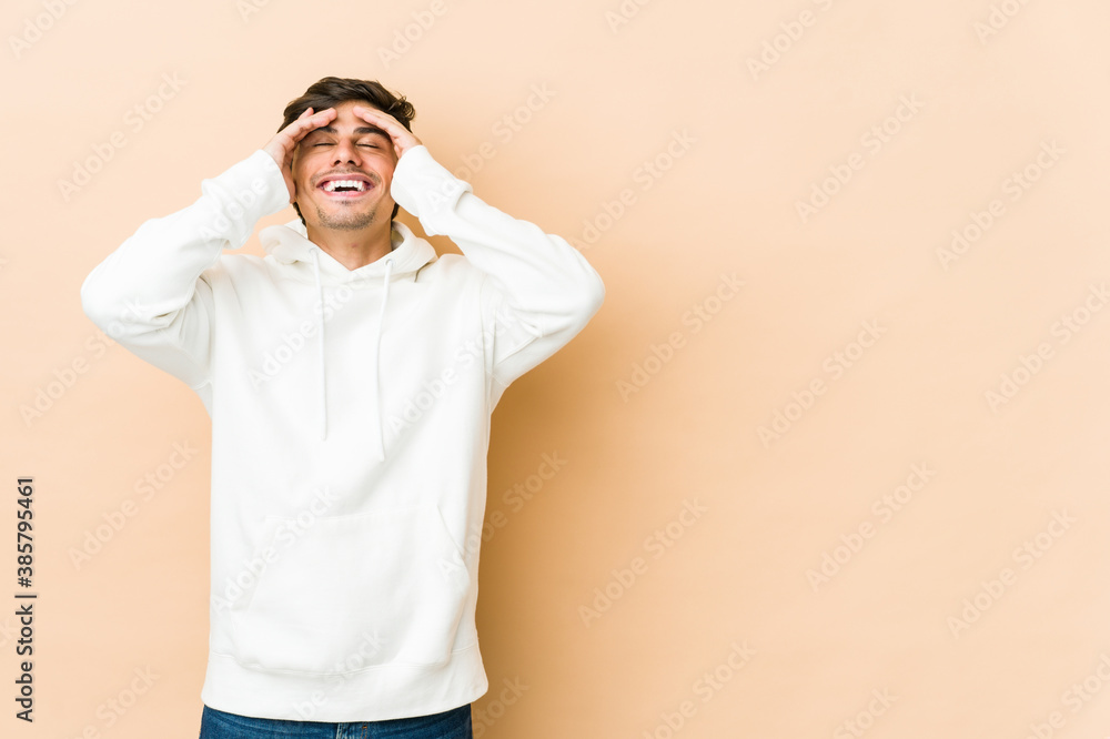 Young cool man laughs joyfully keeping hands on head. Happiness concept. Young cool man laughs joyfully keeping hands on head. Happiness concept.