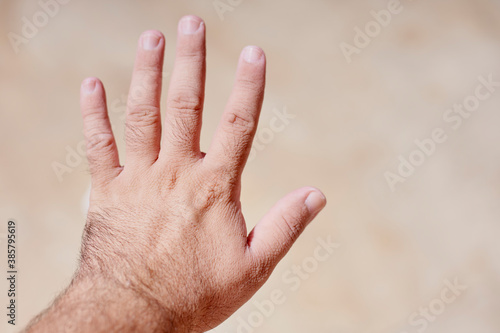A man shocked with wrinkly and pruney skin of his hands after the bath, or being in water