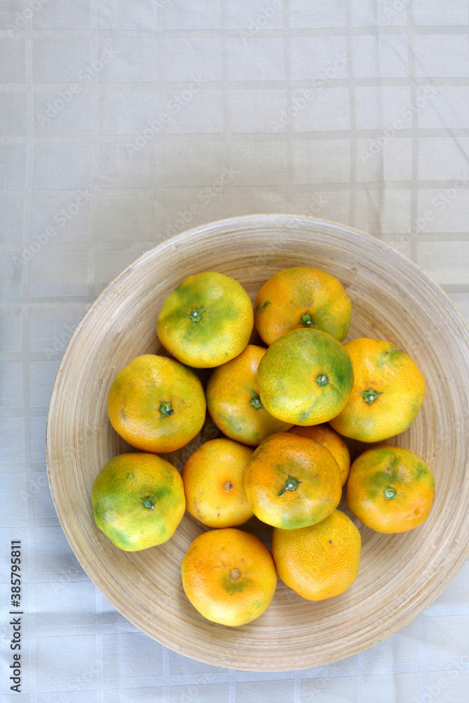 Wooden bowl full of tangerines on a table. Top view. Wooden bowl full of tangerines on a table. Top view.