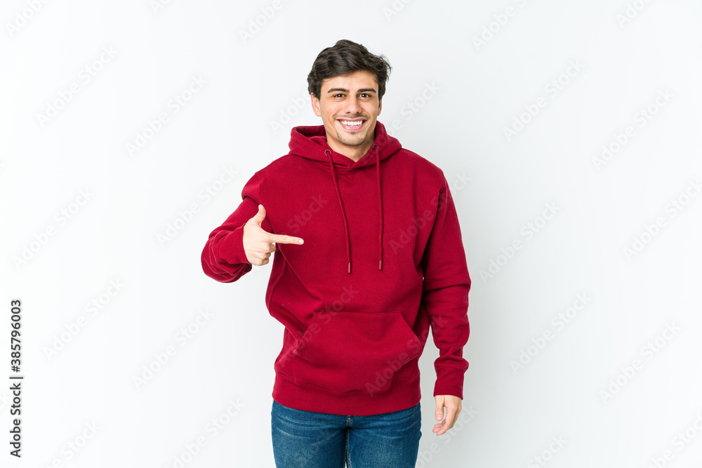 Fototapeta premium Young cool man person pointing by hand to a shirt copy space, proud and confident