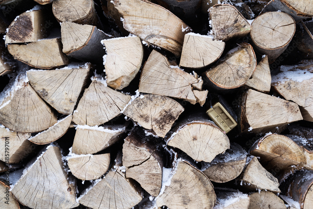 Fototapeta premium Natural background, stack of wood with snow between them.
