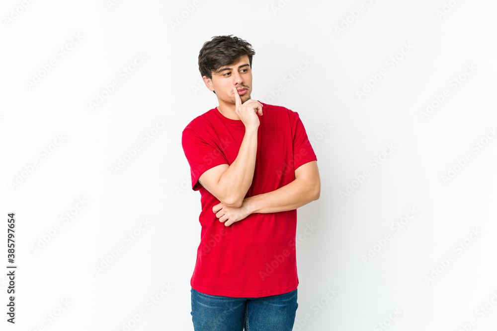 Fototapeta premium Young cool man looking sideways with doubtful and skeptical expression.