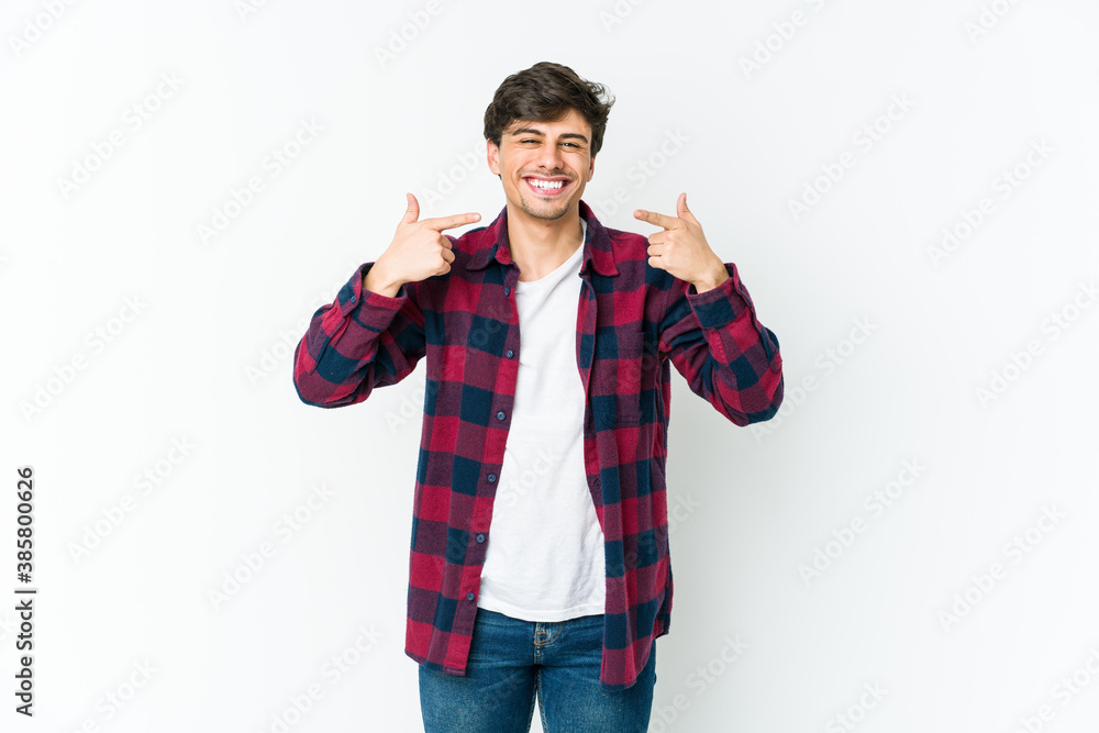 Young cool man smiles, pointing fingers at mouth. Young cool man smiles, pointing fingers at mouth.