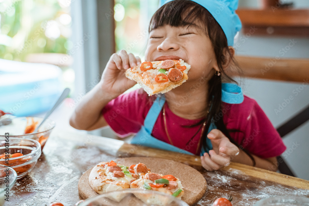 Little child girl eating pizza slices as symbol of best food after make it Little child girl eating pizza slices as symbol of best food after make it