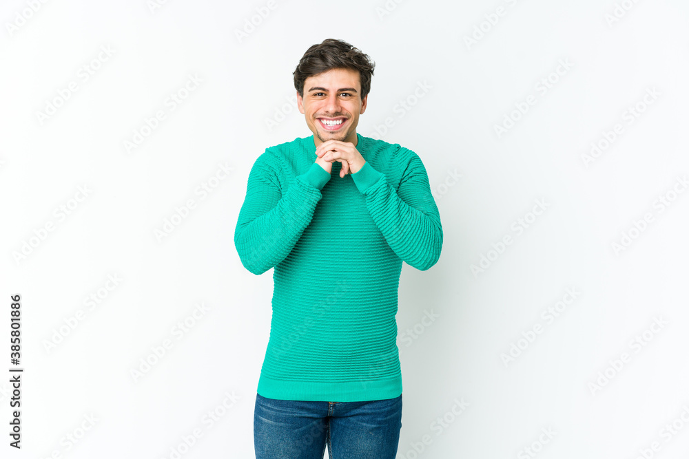 Fototapeta premium Young cool man keeps hands under chin, is looking happily aside.