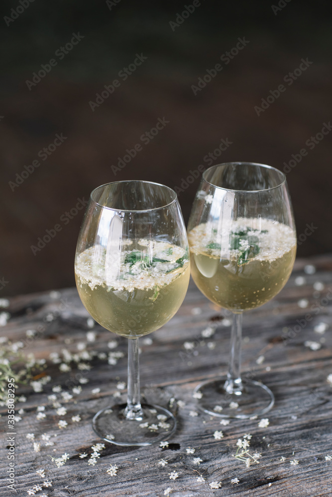 Close-up of fresh cocktail with flowers in wineglass on wooden table Close-up of fresh cocktail with flowers in wineglass on wooden table