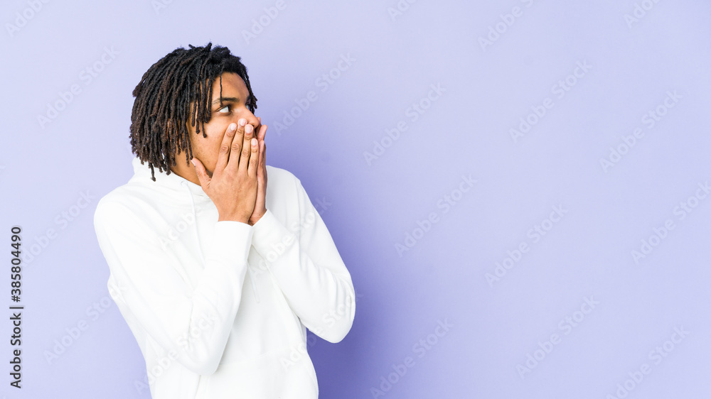 Young african american rasta man thoughtful looking to a copy space covering mouth with hand. Young african american rasta man thoughtful looking to a copy space covering mouth with hand.