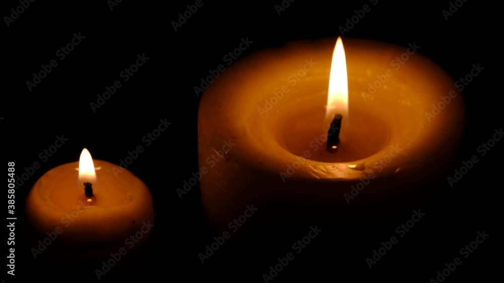 Two stearin candles are burning on a black background high resolution video clip Two stearin candles are burning on a black background high resolution video clip