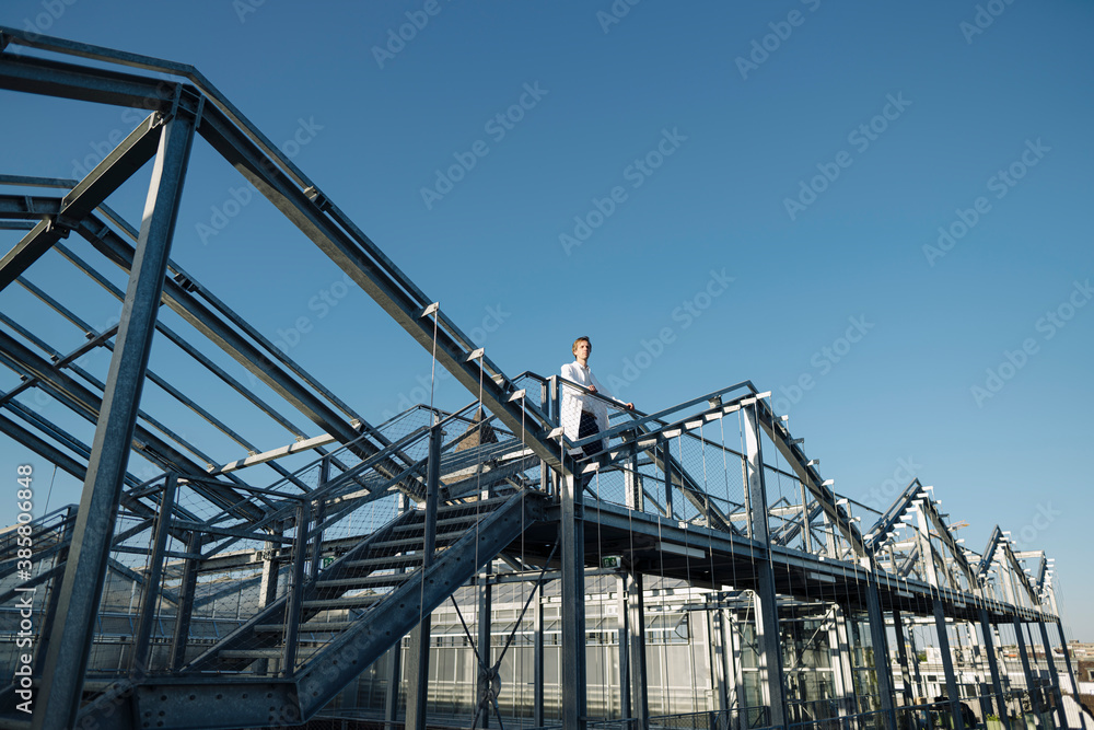 Scientist on a metal construction under blue sky Scientist on a metal construction under blue sky