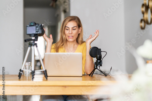 Female vlogger using laptop at home photo