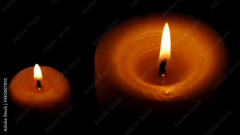 Two stearin candles are burning on a black background high resolution video clip Two stearin candles are burning on a black background high resolution video clip