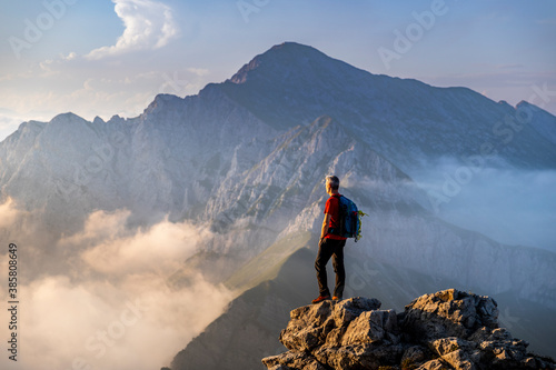 Man standing on top of mountain at Bergamasque Alps, Italy photo