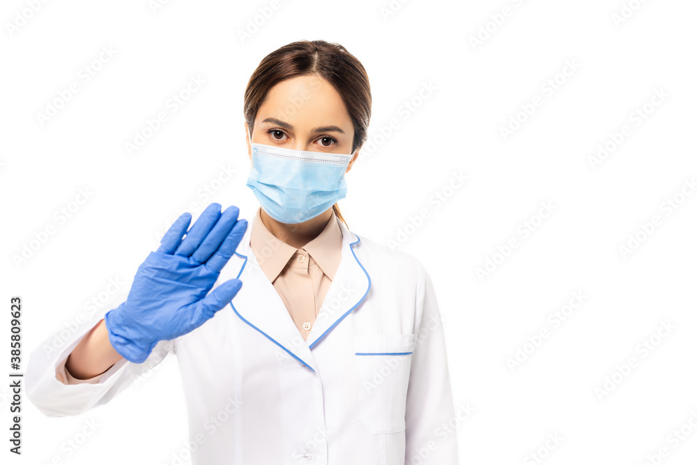 Doctor in medical mask and latex glove showing stop gesture isolated on white