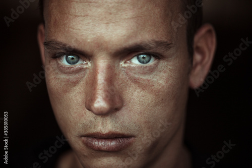 Close-up of man with gray eyes against wall photo