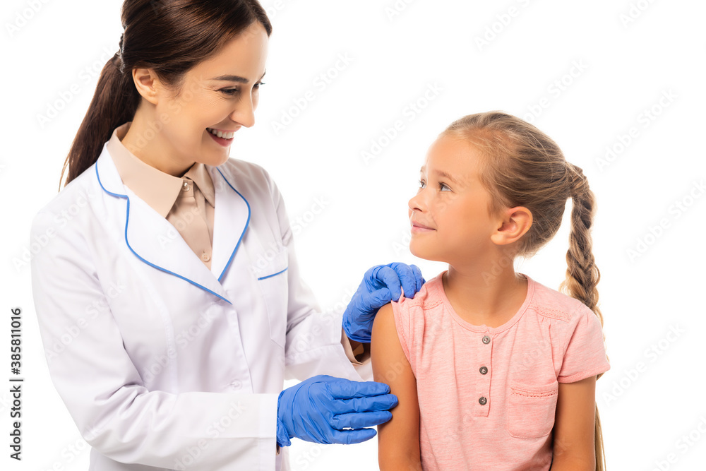 Smiling doctor in latex gloves looking at kid isolated on white Smiling doctor in latex gloves looking at kid isolated on white