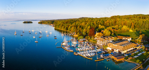 Germany, Bavaria, Poecking, Drone view of sailboats moored in marina on forested shore of Lake Starnberg in spring photo