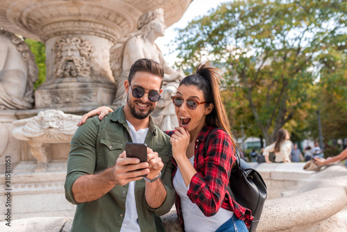 Photography A couple in the city enjoying the content seen of their mobile phone