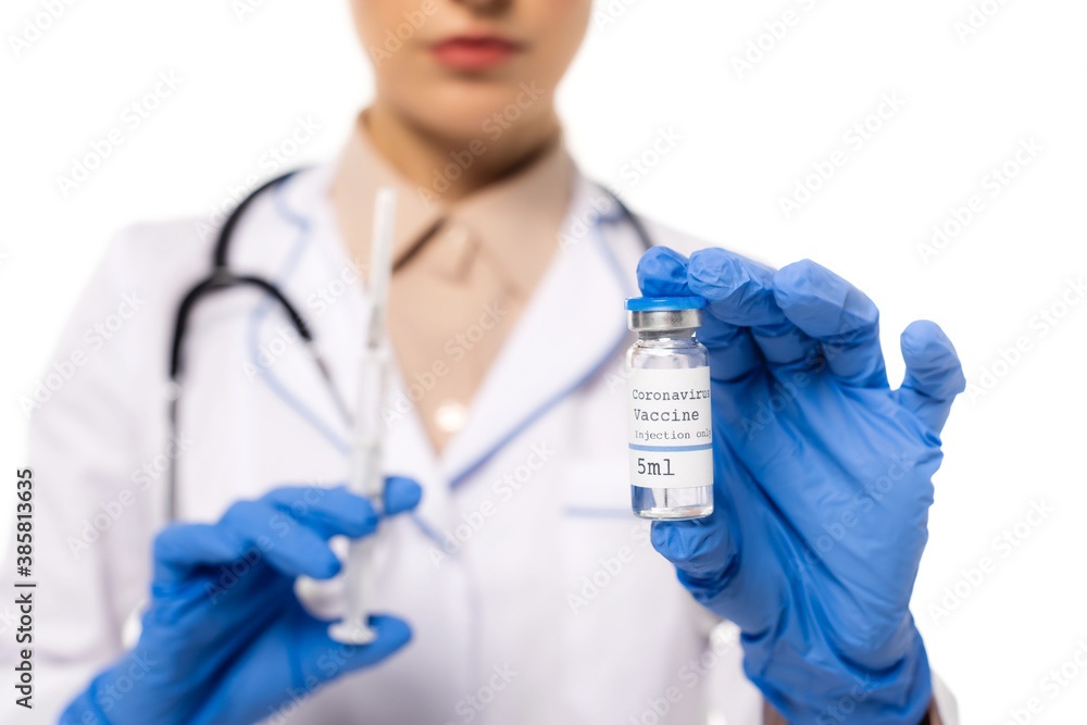 Cropped view of doctor in latex gloves holding vaccine with coronavirus lettering and syringe isolated on white Cropped view of doctor in latex gloves holding vaccine with coronavirus lettering and syringe isolated on white