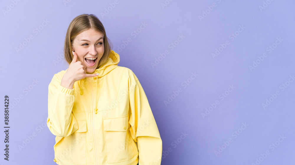 Young blonde woman isolated on purple background showing a mobile phone call gesture with fingers. Young blonde woman isolated on purple background showing a mobile phone call gesture with fingers.