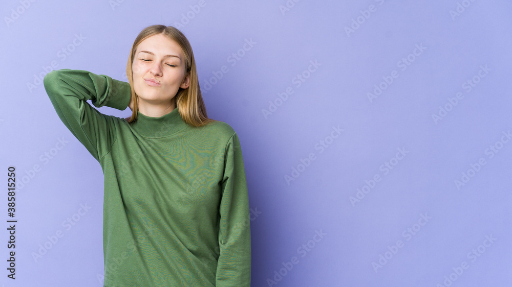 Young blonde woman isolated on purple background having a neck pain due to stress, massaging and touching it with hand. Young blonde woman isolated on purple background having a neck pain due to stress, massaging and touching it with hand.