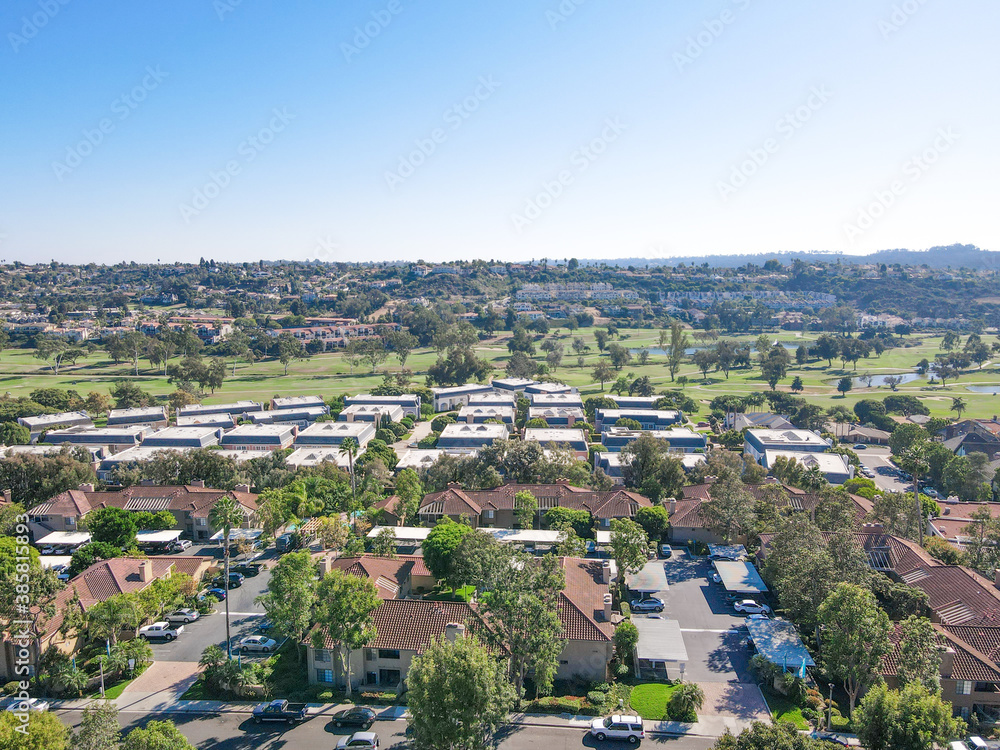 Aerial view of houses and condos with golf on the background in Carlsbad, North County San Diego, California, USA.