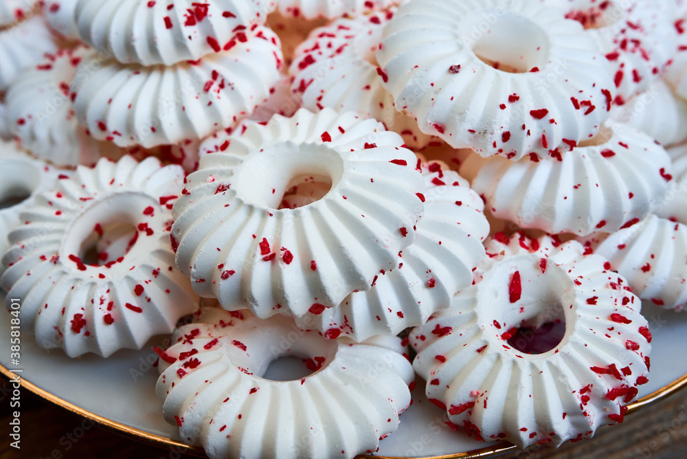 Background of white meringue cakes with red pastry crumb sprinkles