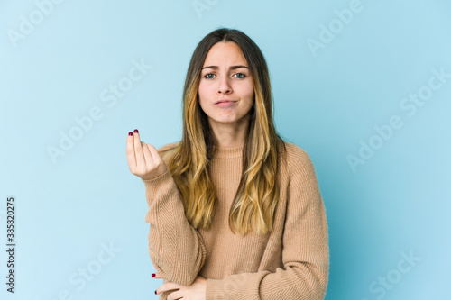 Young caucasian woman isolated on blue background showing that she has no money.