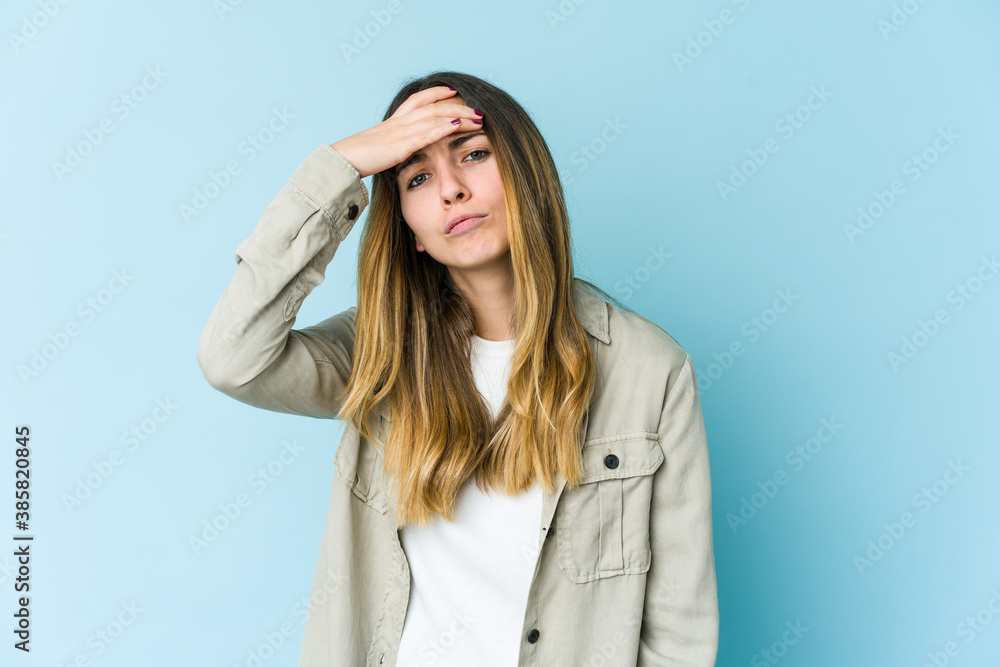 Young caucasian woman isolated on blue background touching temples and having headache. Young caucasian woman isolated on blue background touching temples and having headache.