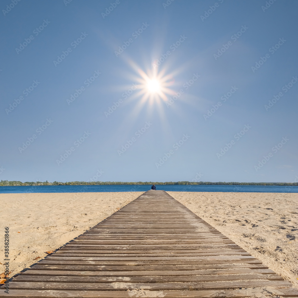 wooden road over a sandy sea beach under a hot sun, summer vacation background